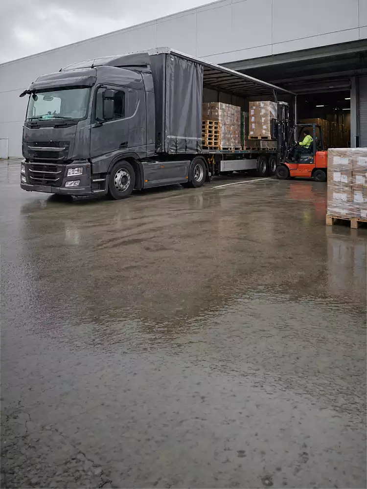 Transport trailer utenfor godsterminal som lastes av en gaffeltruck
